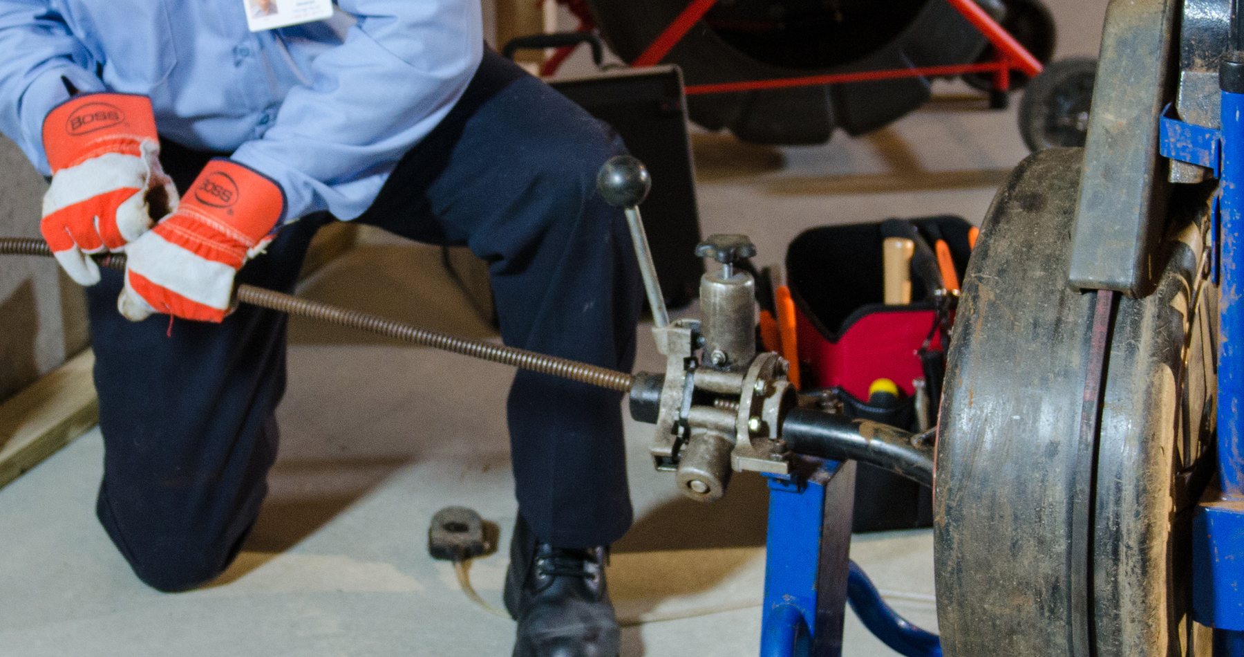 Technicien utilisant un furet mécanique professionnel pour déboucher une canalisation